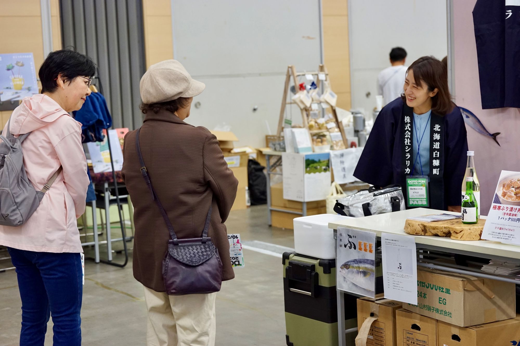 ブースで来場者と対話するスタッフ